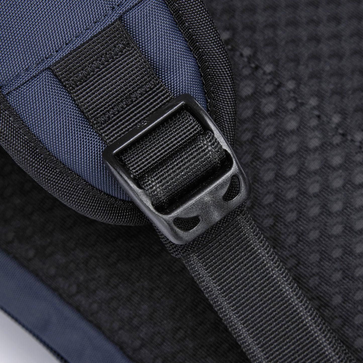 Close-up of a black buckle on the dark recycled polyester strap of the Pacsafe® V Tech Anti-theft Sling Pack.