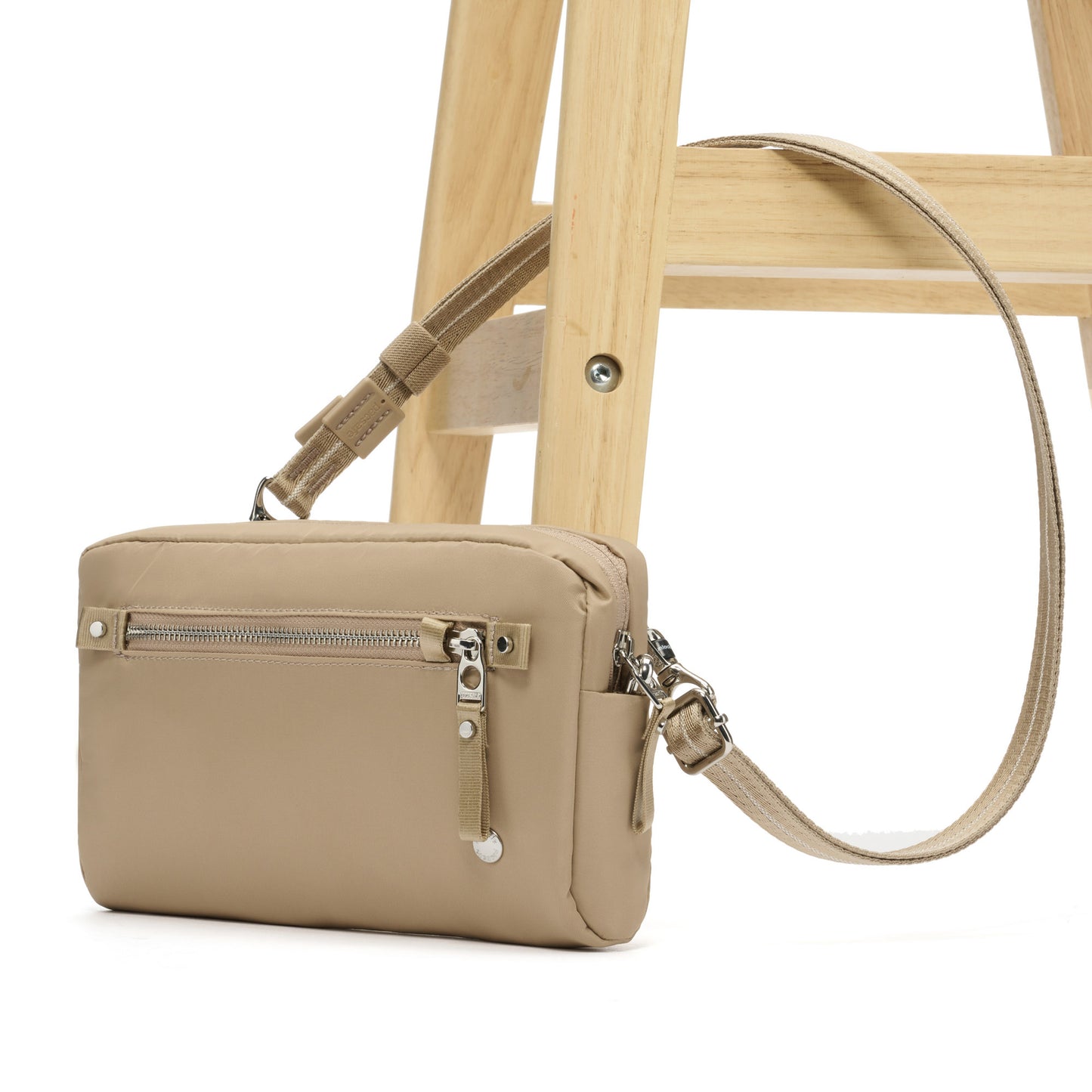 Pacsafe® W Anti-theft 3-in-1 Sling, taupe, attached through wooden chair leg.