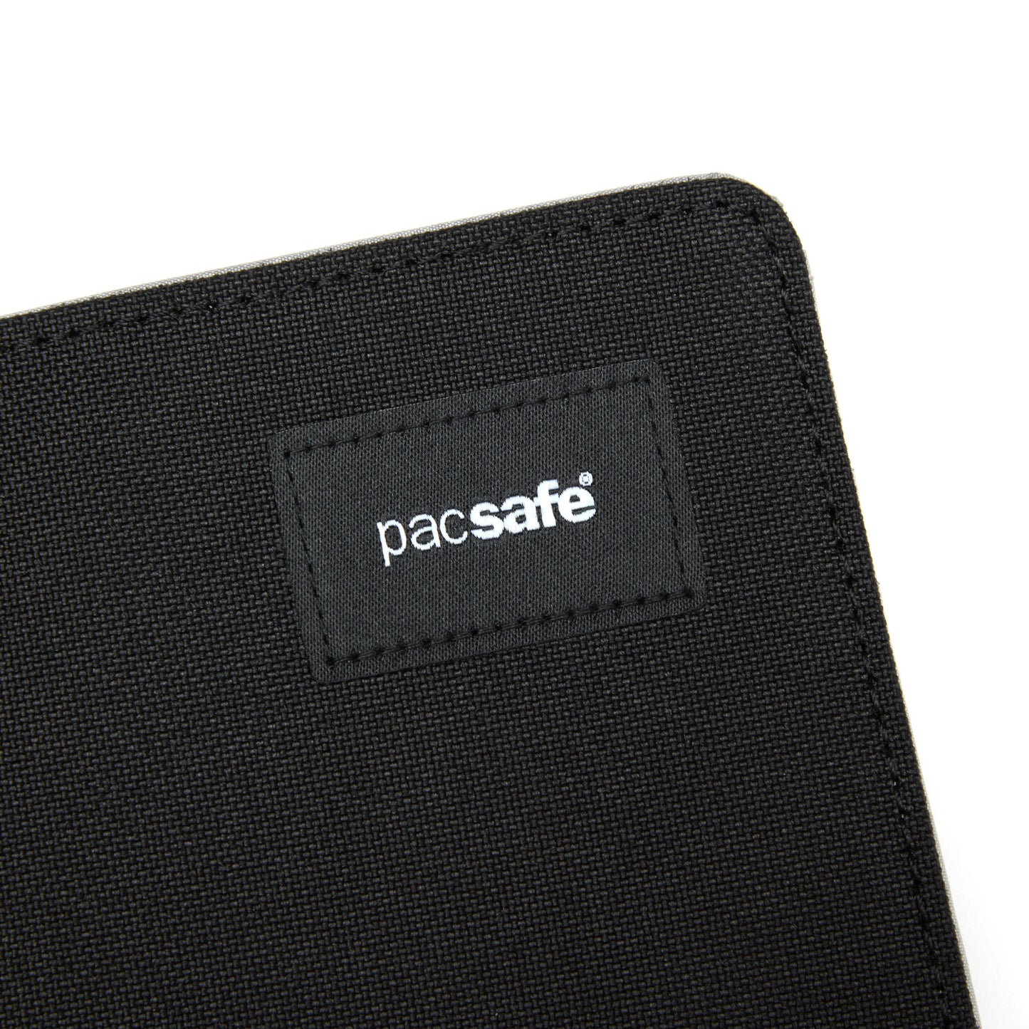 Close up of front top corner of black Pacsafe® RFIDsafe™ RFID Blocking Bifold Wallet with black logo patch.
