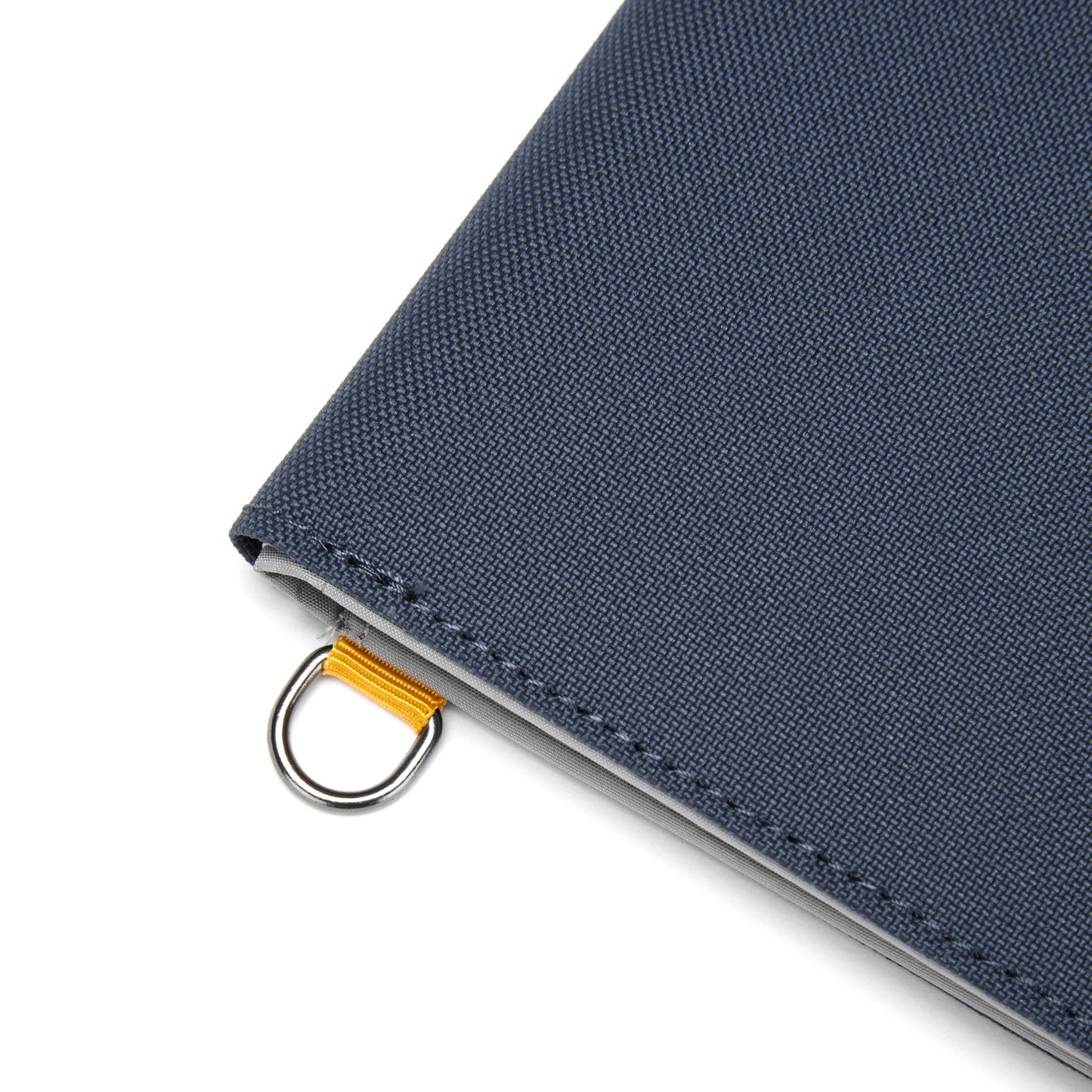 Corner of a Pacsafe® RFIDsafe™ Wallet with RFID blocking, yellow ribbon, & silver ring.