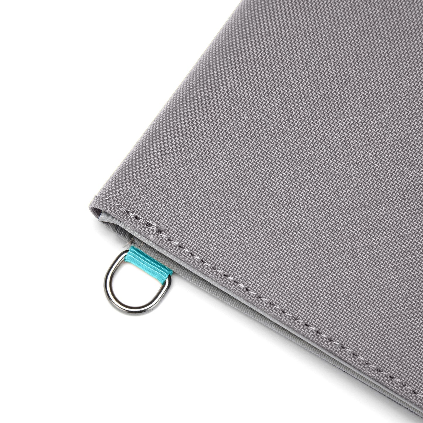 Close-up of a Pacsafe® RFIDsafe™ wallet corner, featuring stone grey fabric, metal ring, and turquoise ribbon.