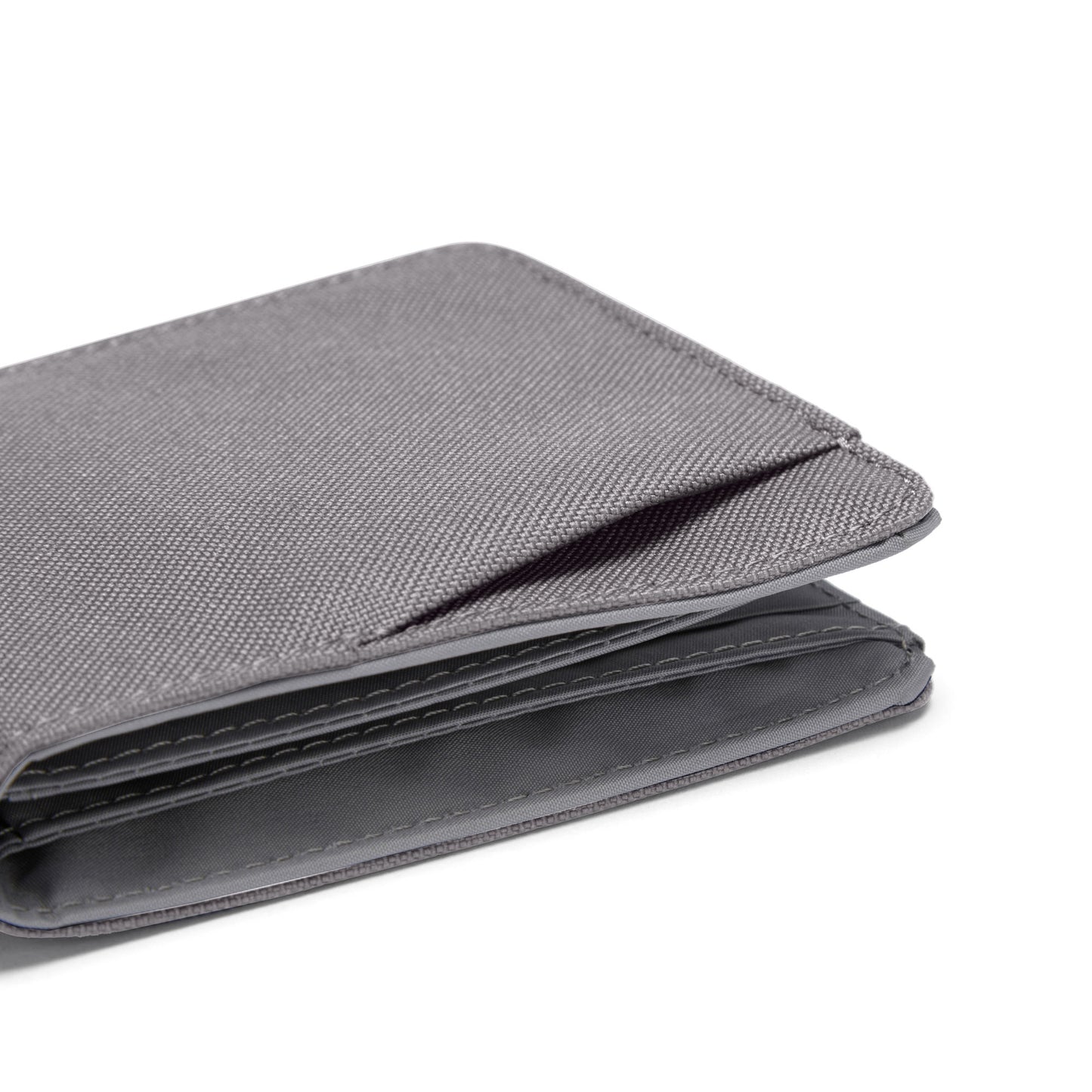 Pacsafe® RFIDsafe™ stone grey fabric bifold wallet with RFID protection, compartments shown on white background.