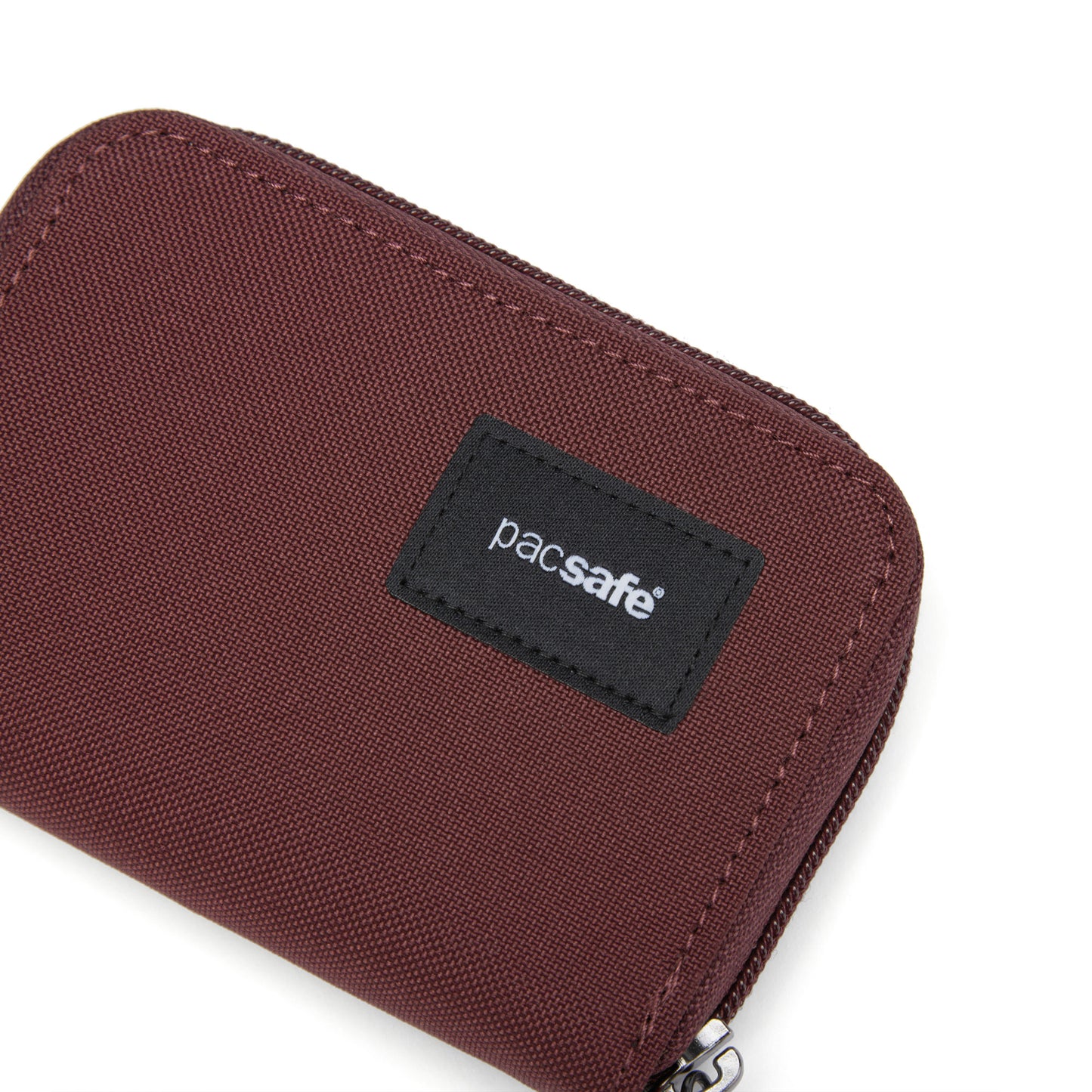 A Pacsafe RFIDsafe garnet red card wallet with a black label on a white background.