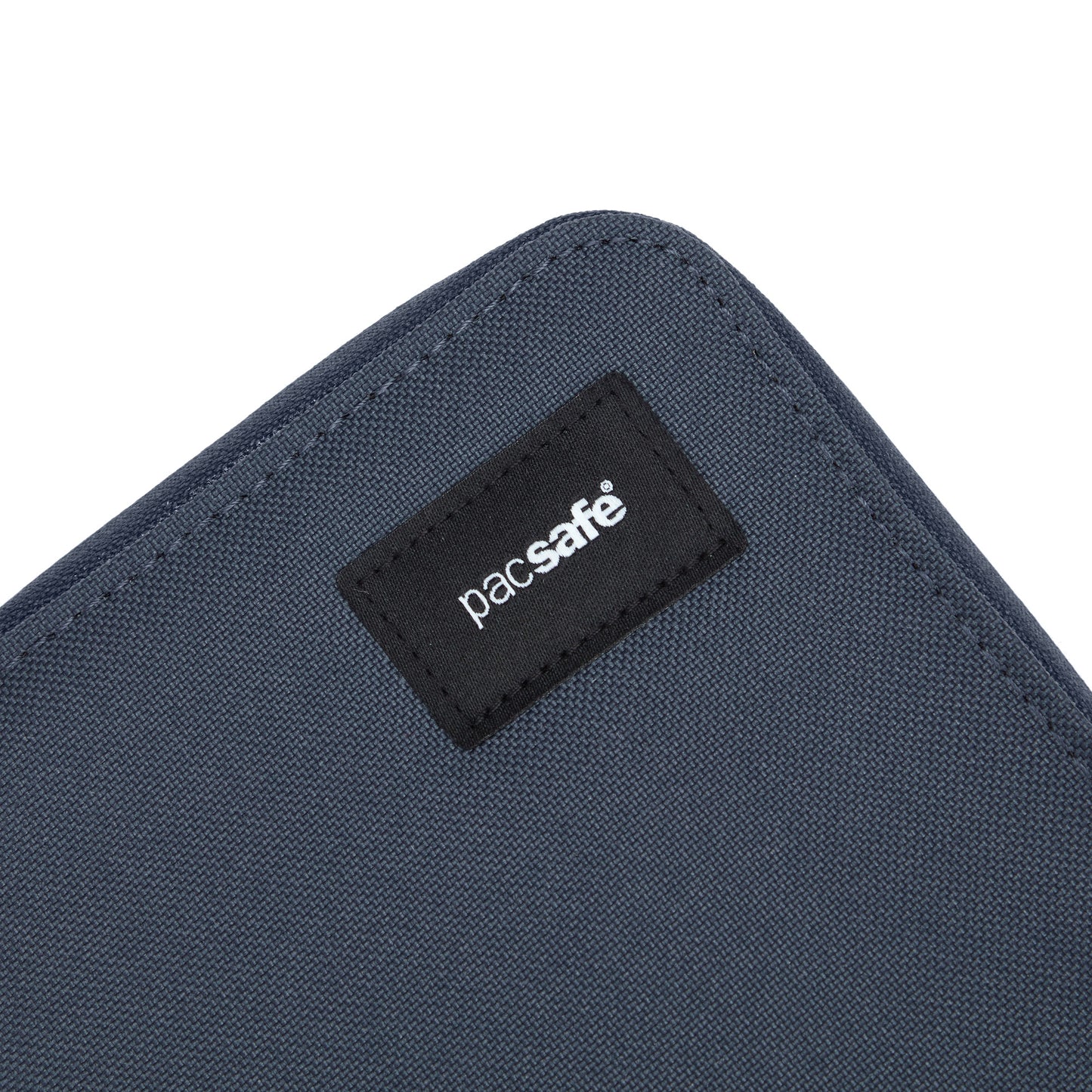 Close-up of blue fabric labeled "Pacsafe," crafted from recycled polyester, from the Pacsafe RFID Blocking Organizer.