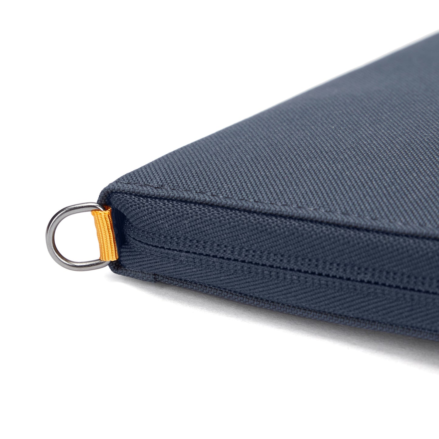 Close-up of Pacsafe® RFIDsafe™ corner: blue recycled polyester with metal ring and yellow fabric loop.