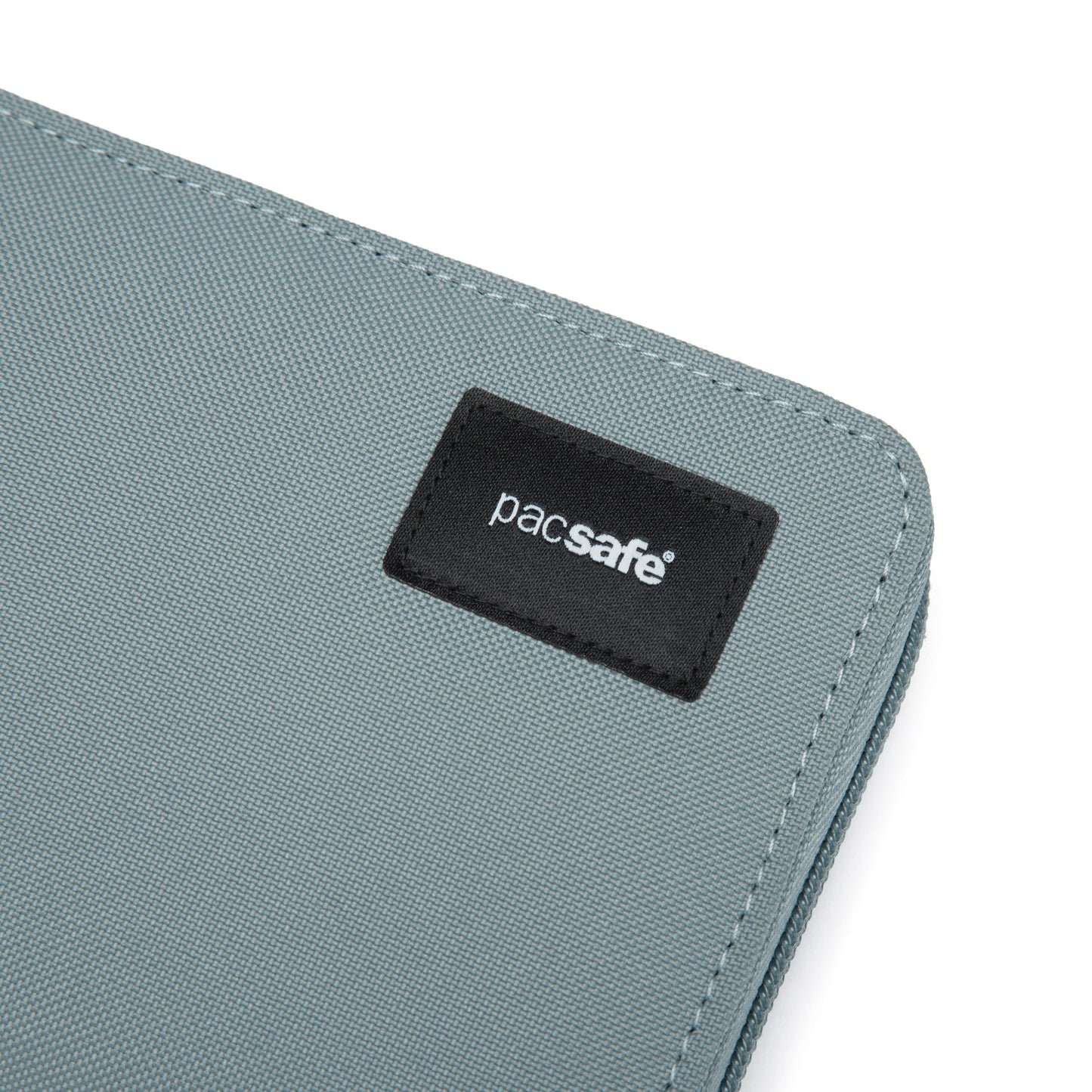 Close up of black logo patch in top right corner of fresh mint Pacsafe® RFIDsafe™ RFID Blocking Continental Wallet