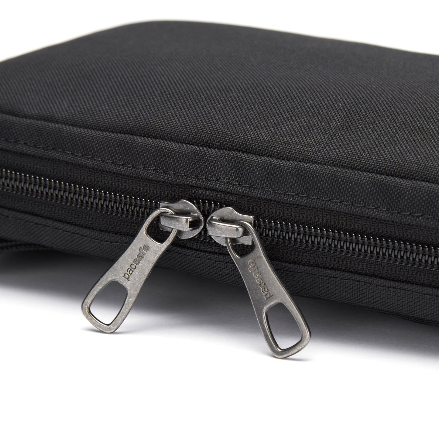 Close-up of a Pacsafe® RFIDsafe™ RFID Blocking Tech Crossbody, black fabric with two metal zippers slightly open.