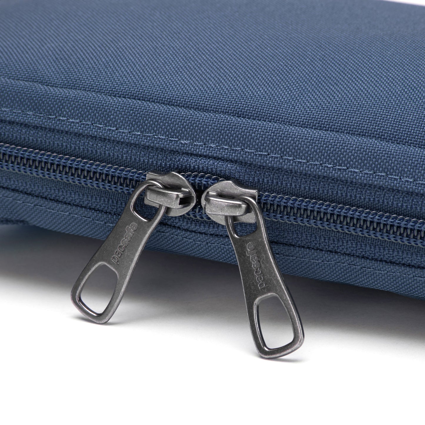 Pacsafe® RFIDsafe™ RFID blocking crossbody with double zippers in blue on a white background.