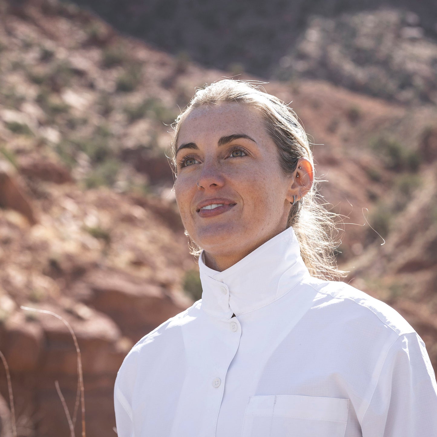Lifestyle image of woman wearing Royal Robbins Expedition III shirt with collar buttoned up to protect against mosquitos.