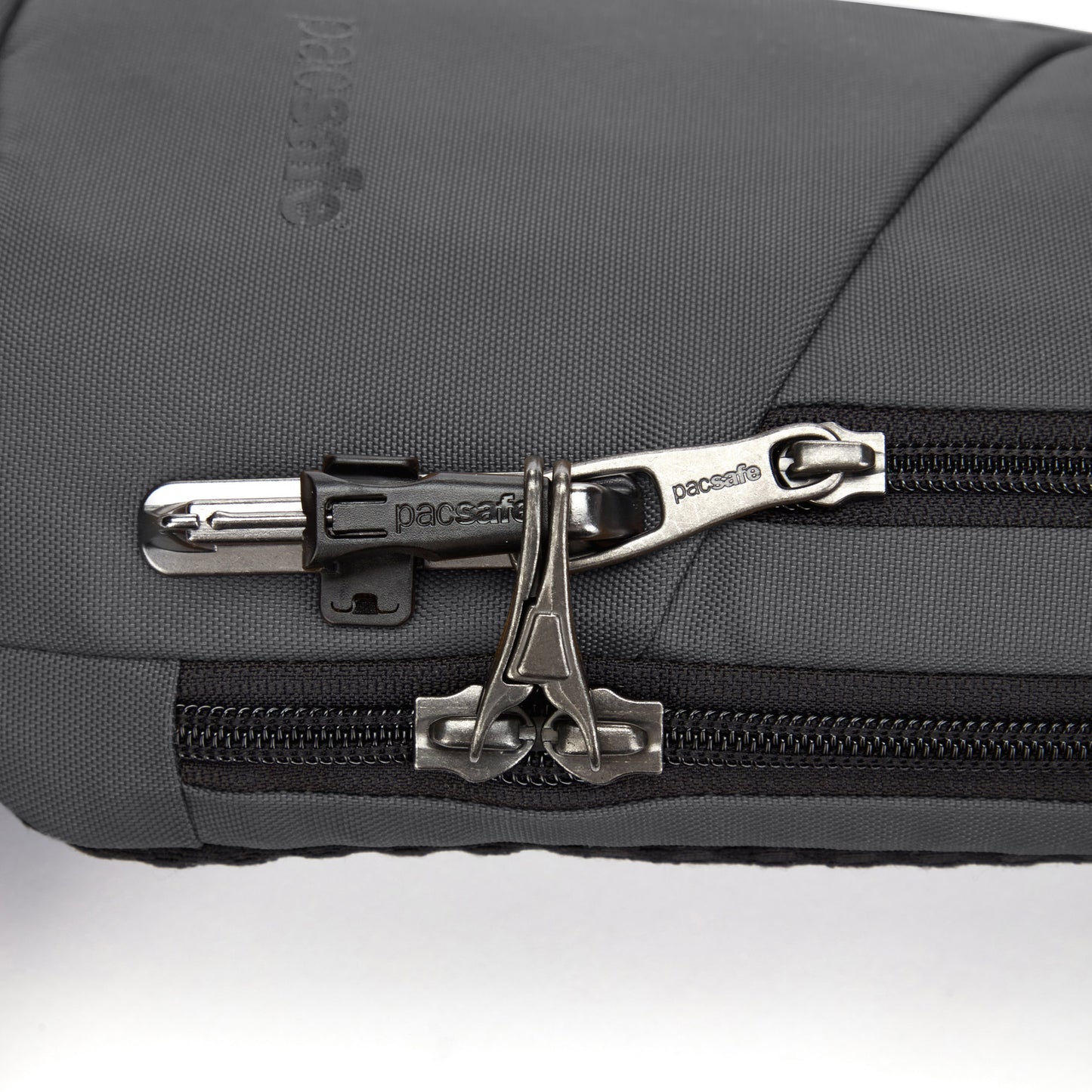 Close-up of a slate Pacsafe® V Anti-theft Action Sling Pack made from recycled polyester, featuring a security zipper lock.