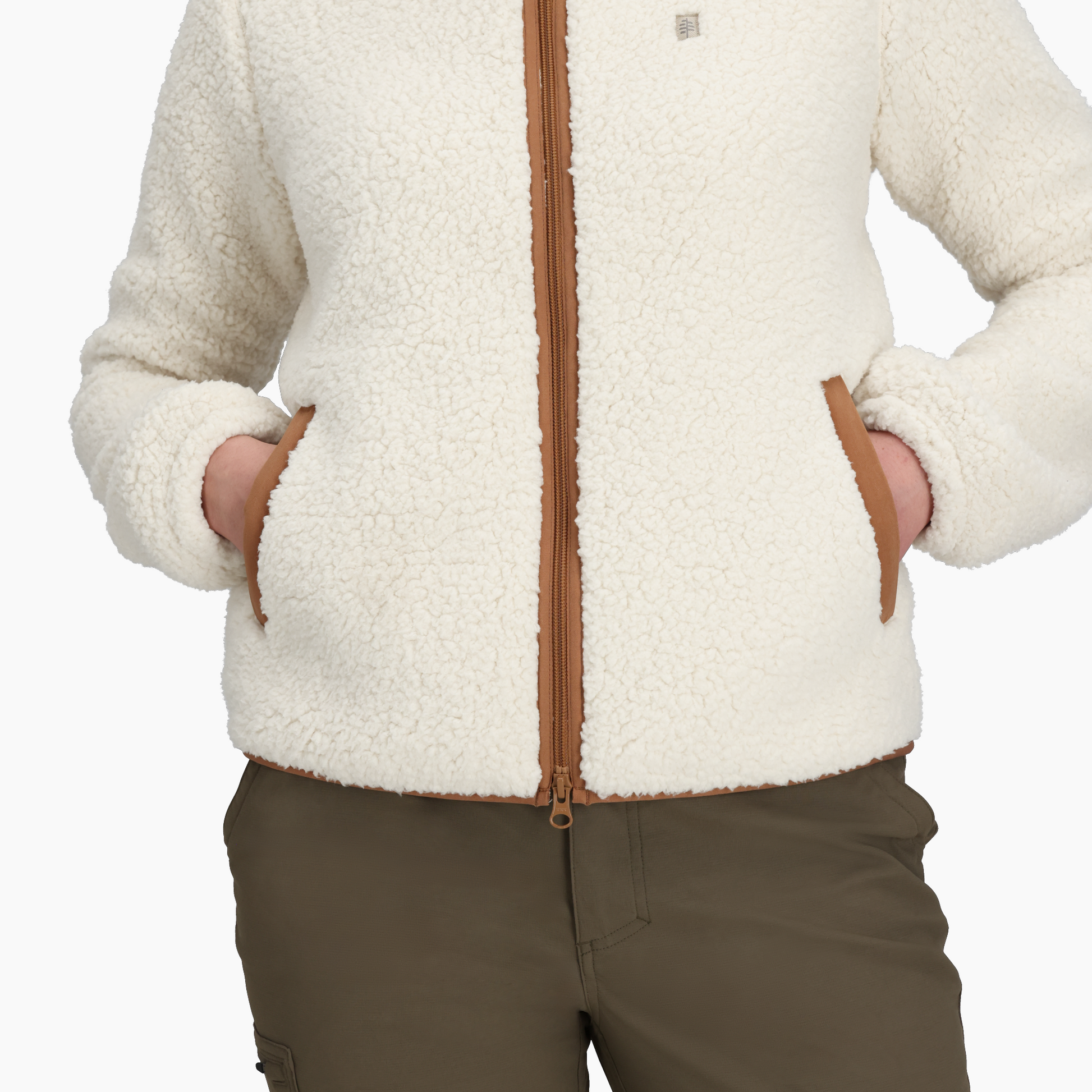 Woman in Royal Robbins Palisades Jacket with hands in pockets and olive green pants, shown shoulders to hips.