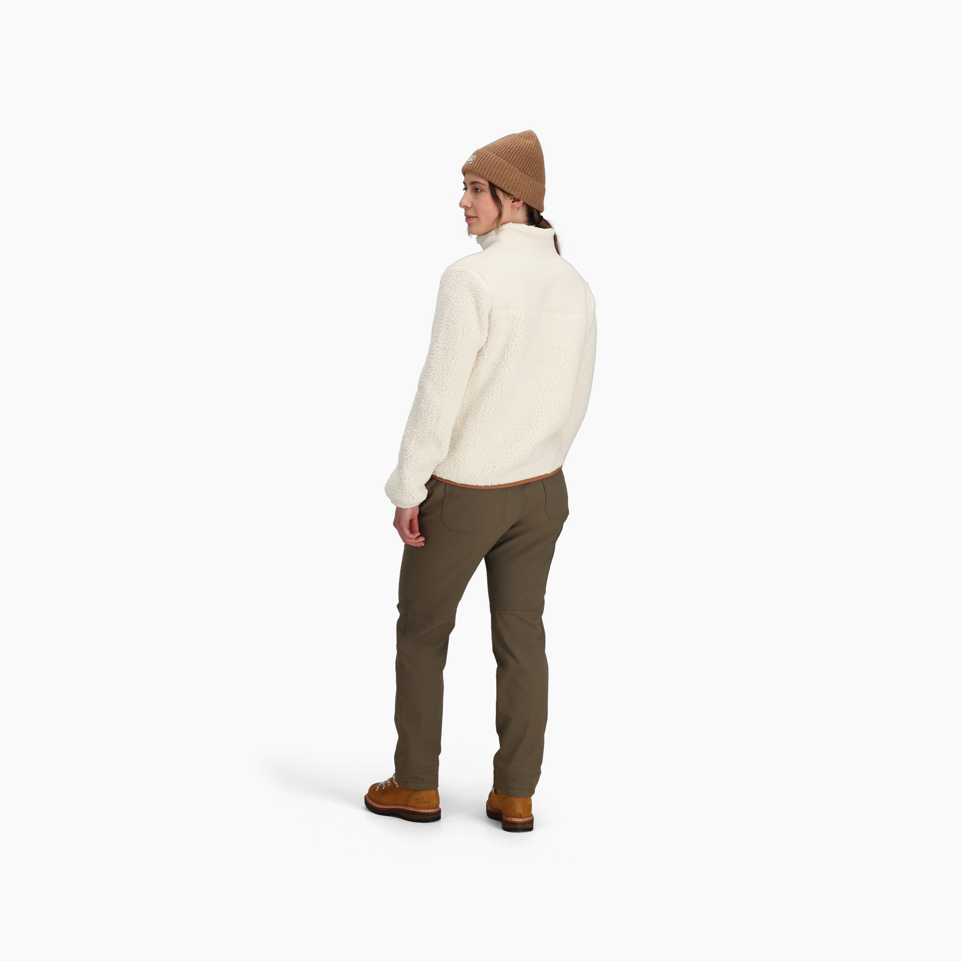 Person wearing a tan beanie, Royal Robbins Women's Palisades Jacket, olive pants, and brown shoes, facing backward.