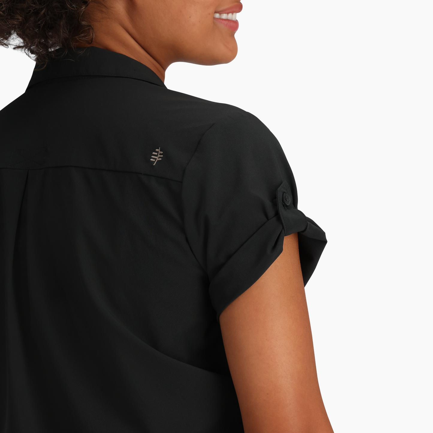 Woman in a Royal Robbins Spotless Evolution Meadow short sleeve shirt with a logo on the back shoulder.