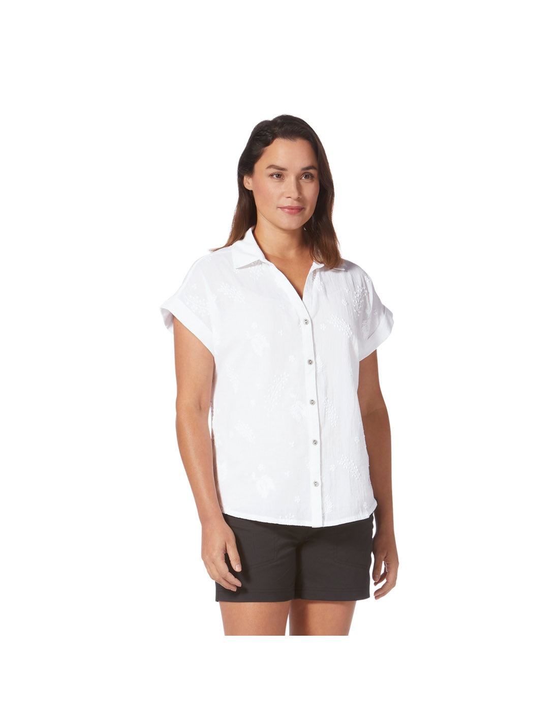 Woman wearing white Royal Robbins Women's Oasis Short Sleeve & black shorts stands against a white background, ready for adventure.
