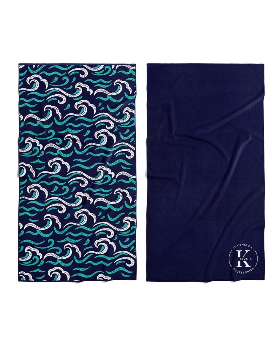 Two compact K5 Microfibre Beach Towels—one wave patterned, one solid navy—ultra-absorbent for easy travel.