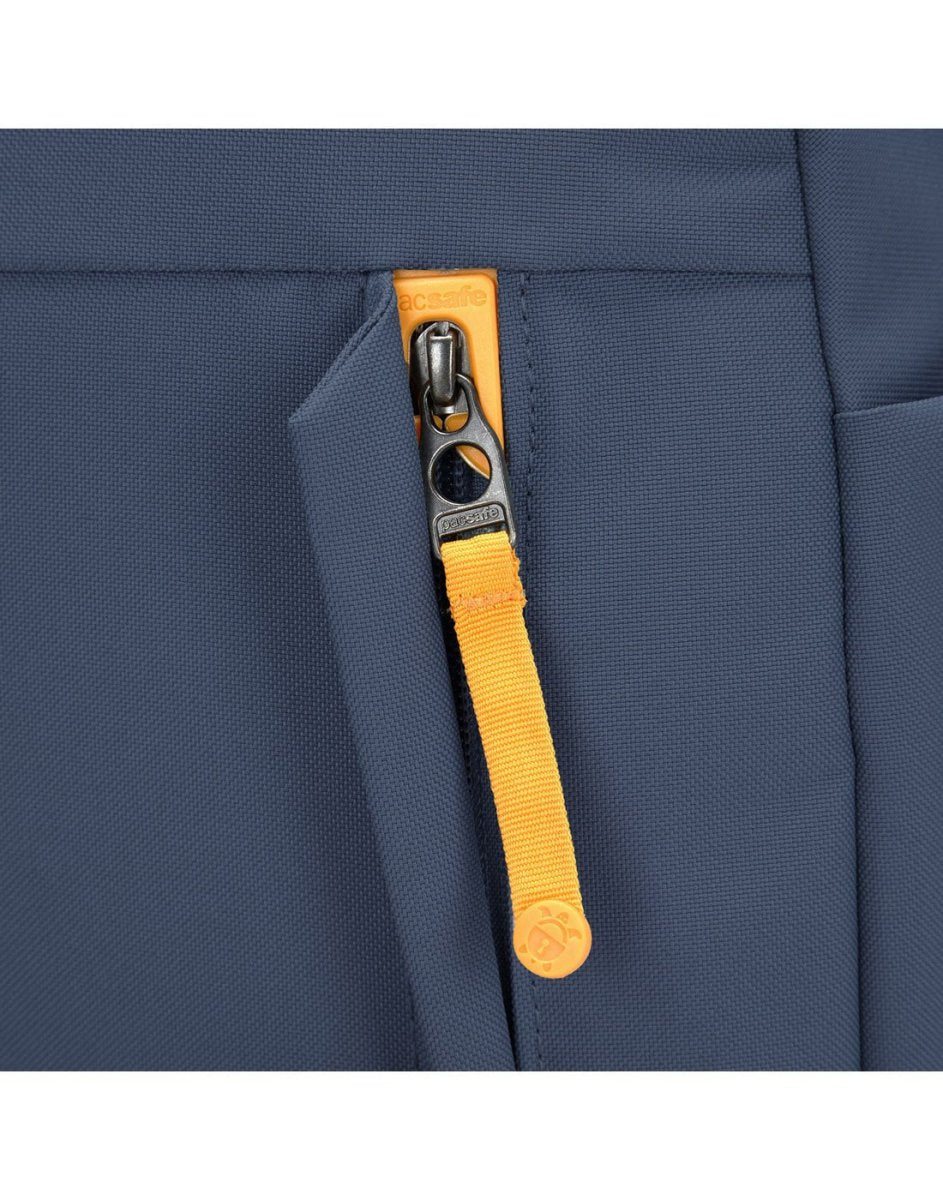 Close-up of Pacsafe® GO 15L Backpack's blue recycled polyester zipper pocket with orange pull, yellow tab.