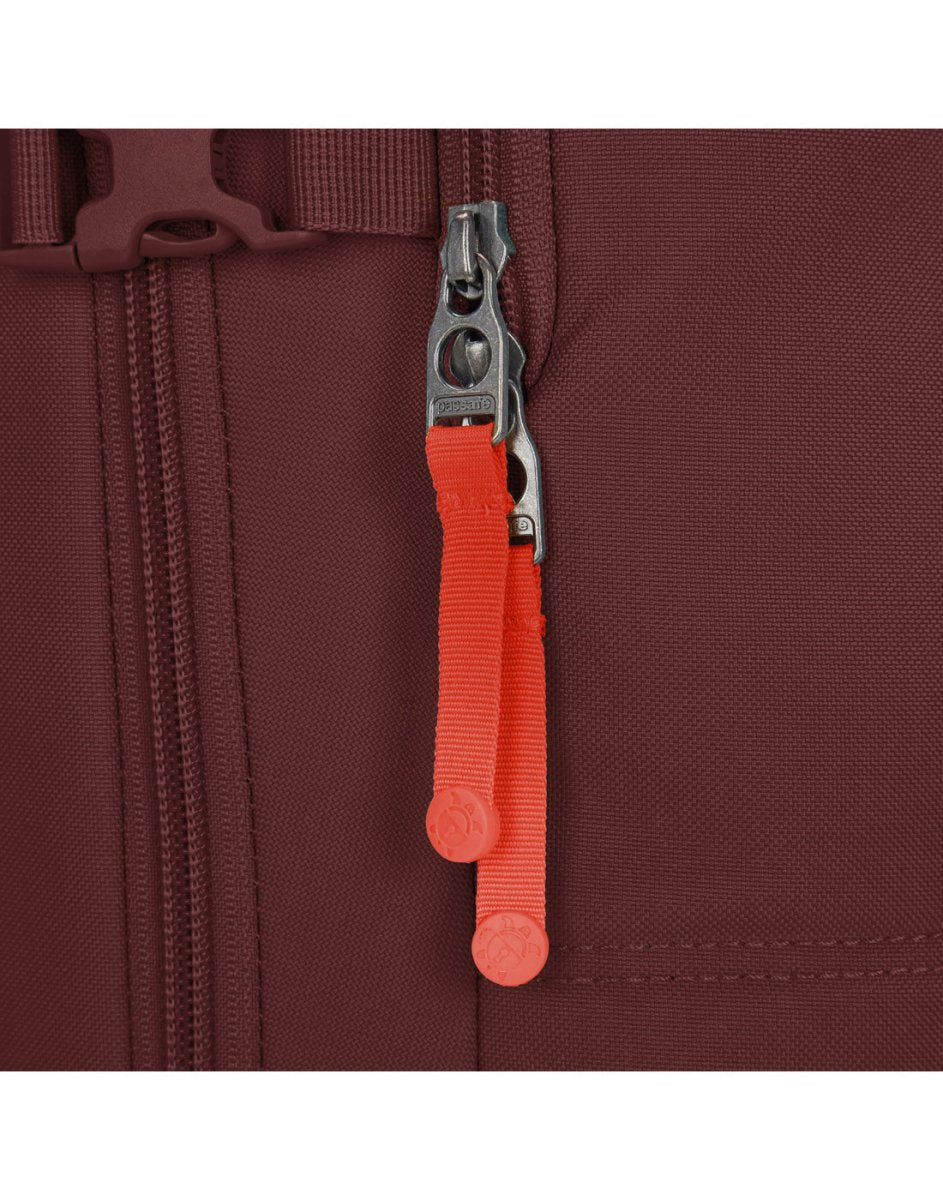 Close-up of Pacsafe® GO 34L silver zipper with red pull tab on maroon recycled polyester backpack.