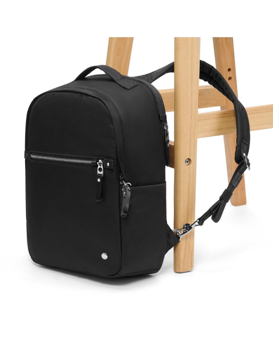 Pacsafe® W 10L Anti-theft Backpack, crafted from recycled polyester, rests against a wooden stool.