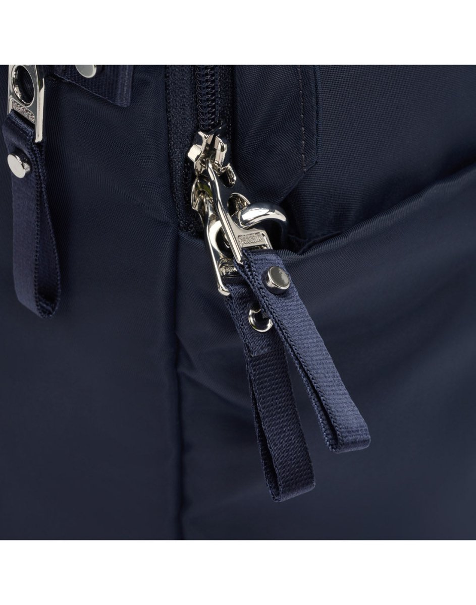 Close-up of Pacsafe W 10L Anti-theft Backpack in navy blue with metal zippers and dark fabric tabs.