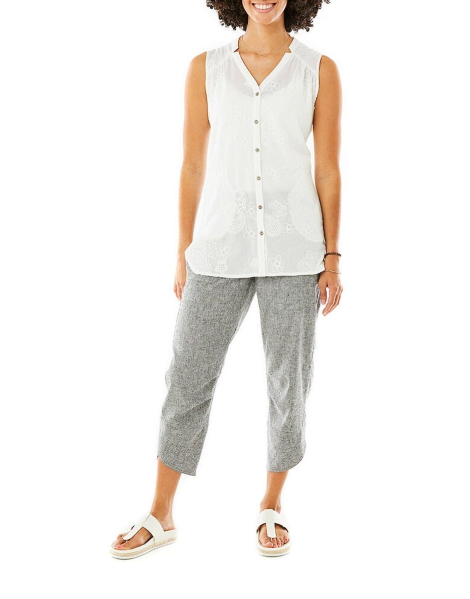 Person wearing Royal Robbins Hempline Capri in gray, a sleeveless white top, and white sandals against plain background.