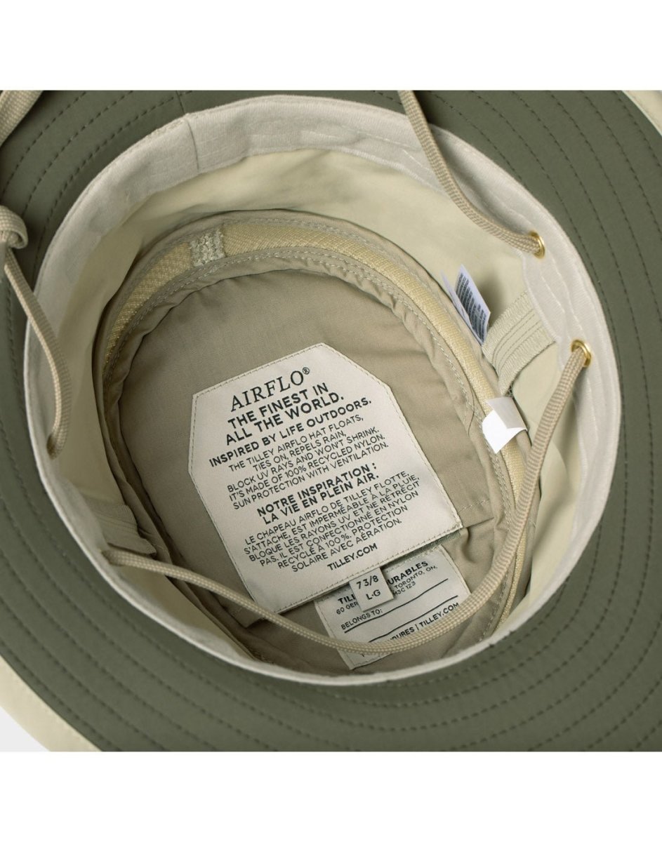 Close-up of Tilley LTM5 Airflo® Hat interior tags showing ventilation and sun-blocking instructions.