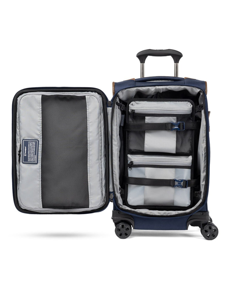 Travelpro Crew™ Classic Carry-on Expandable Spinner in Patriot Blue.  Interior view showing the use of the interior hold-down straps to secure the removable compression packing organizer.