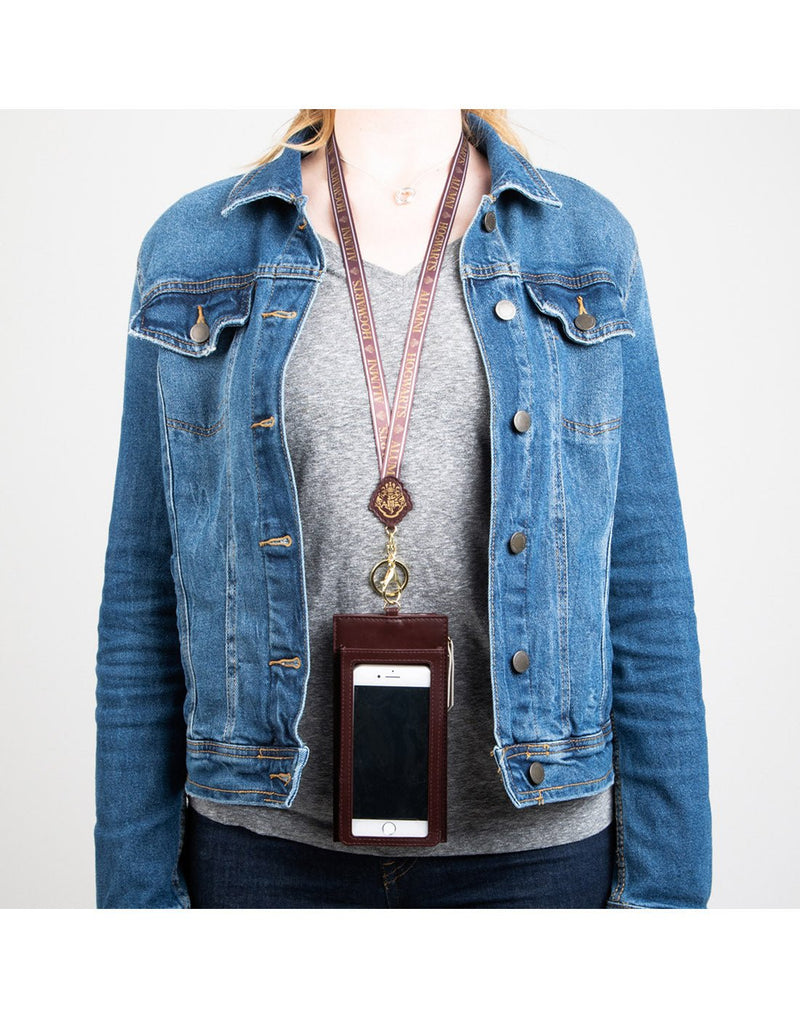 Model wearing grey t-shirt, blue jean jacket open on top and Harry Potter Lanyard with Tech Pouch hanging around the neck