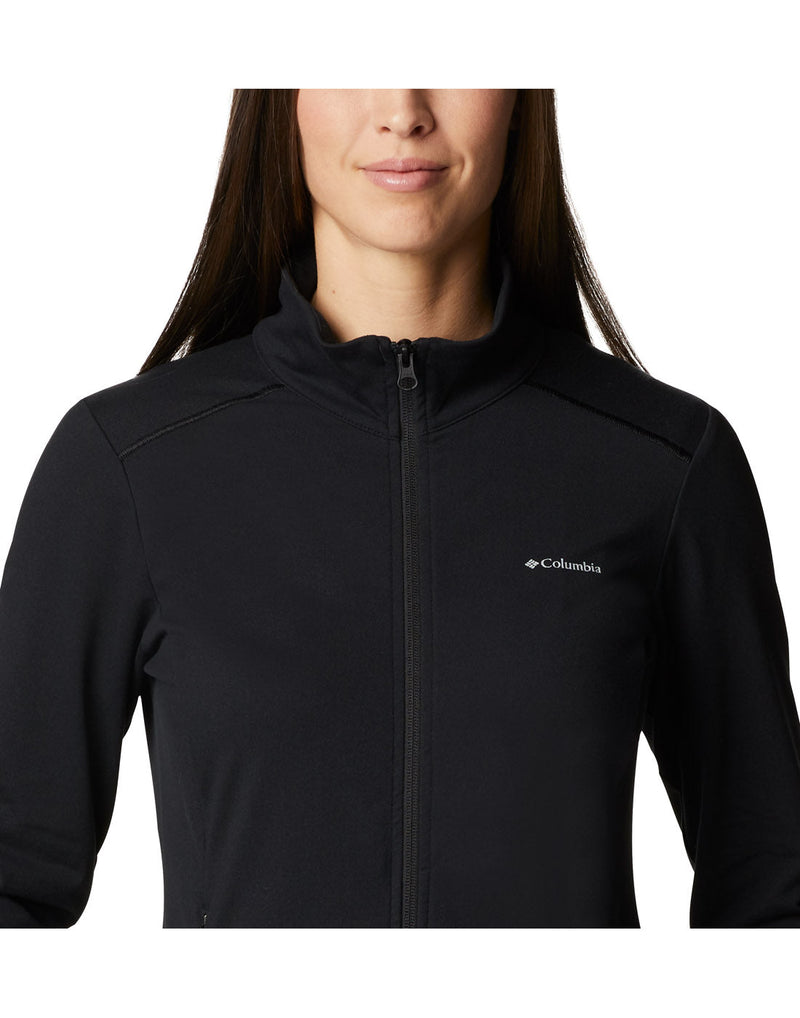 Close up of chest and neckline of Columbia Women's Weekend Adventure™ Full Zip Jacket in black, zipped up, with small white Columbia logo on left chest