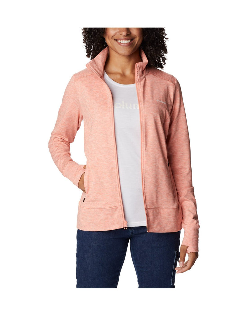 Woman wearing blue jeans, white t-shirt and Columbia Women's Weekend Adventure™ Full Zip Jacket in peach heather, unzipped, front view