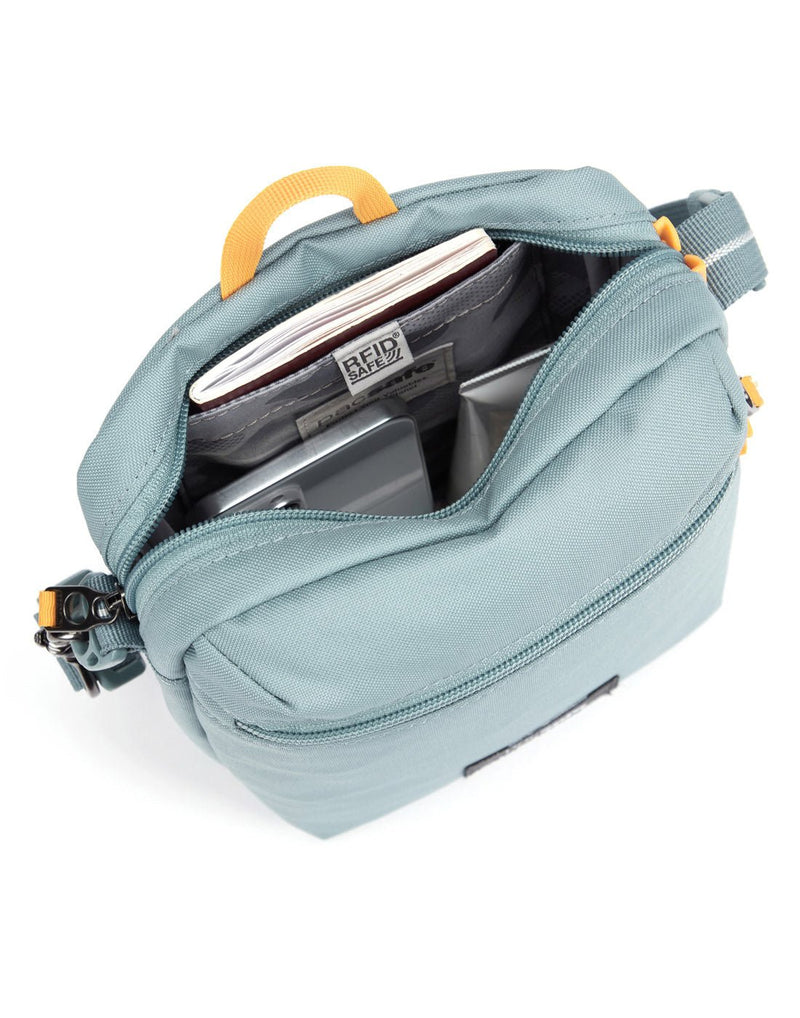 Pacsafe® GO Anti-Theft Festival Crossbody in fresh mint colour, top view with zipper open showing bag interior and RFID blocking pocket.