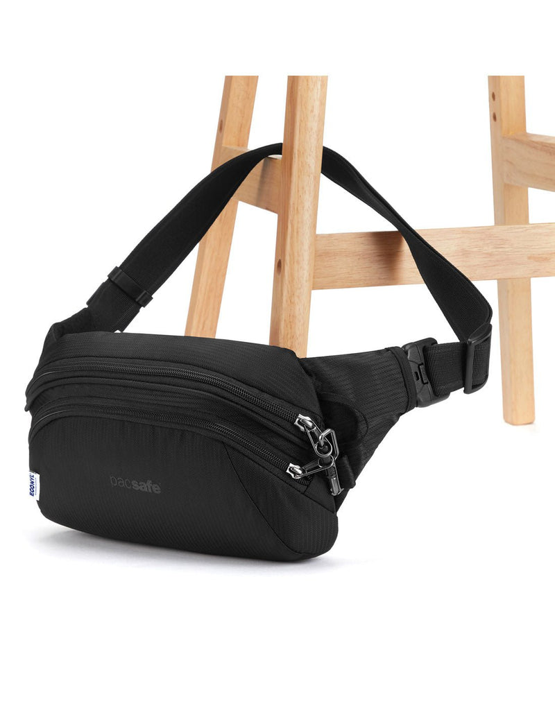 Pacsafe Metrosafe LS120 Anti-theft Hip Pack, black, attached to a chair leg