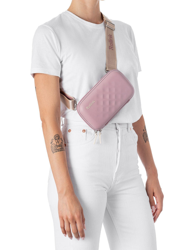 Woman wearing the Rollink Mini Bag Tour in Lavander, as a cross-body with strap shortened so bag is at mid-torso height.