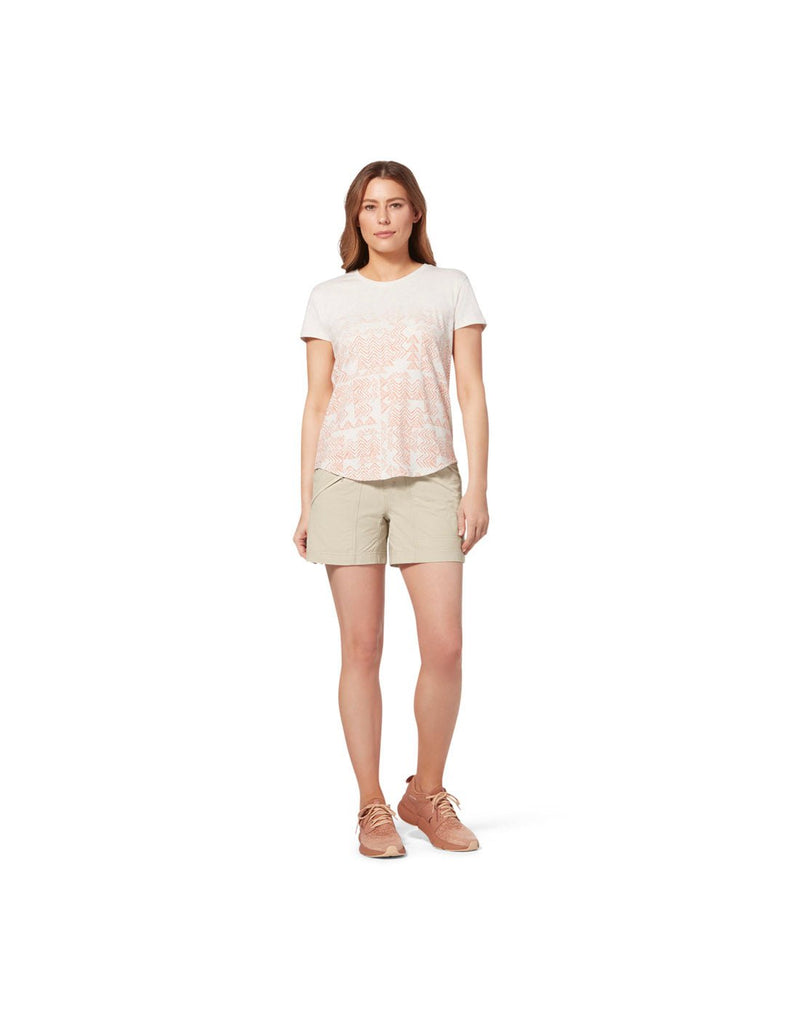 Front view of woman wearing pink top, pink running shoes and Royal Robbins Women's Backcountry Pro Shorts light khaki