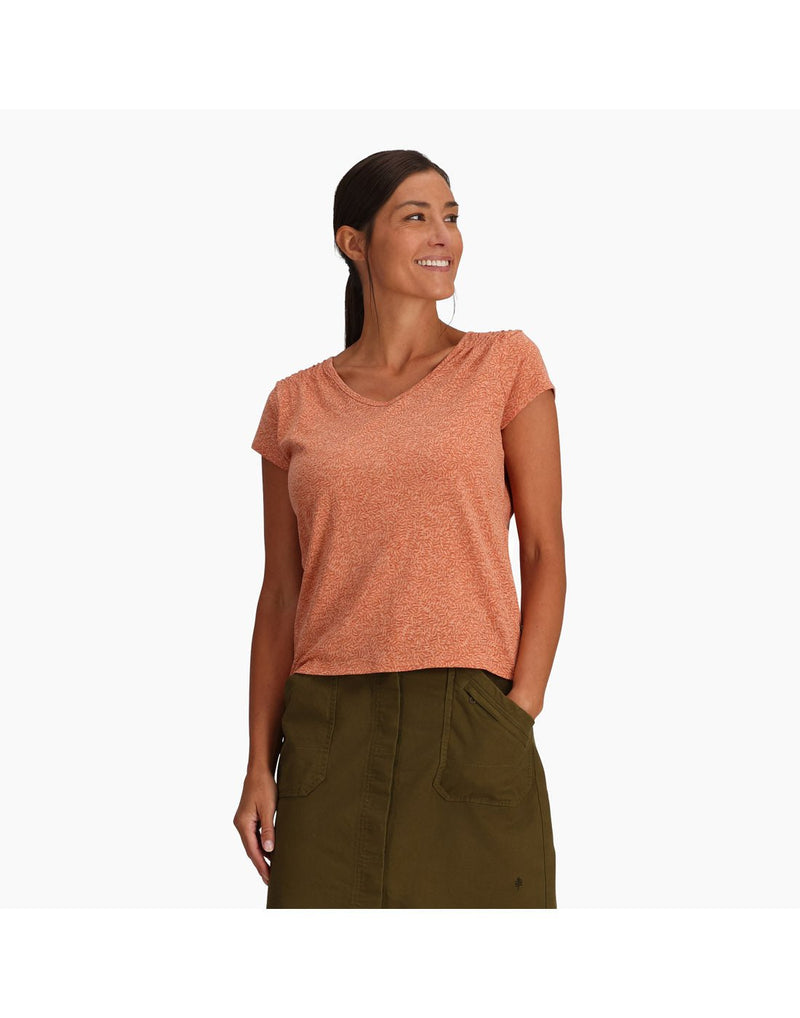 Top half of woman wearing Royal Robbins Women's Featherweight Slub Tee in baked clay with green skirt with one hand in pocket, front view