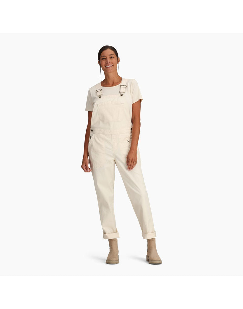 Woman wearing Royal Robbins Women's Half Dome Overall in undyed white over a white t-shirt.  Bottoms of pants are rolled up and she is wearing beige ankle boots.
