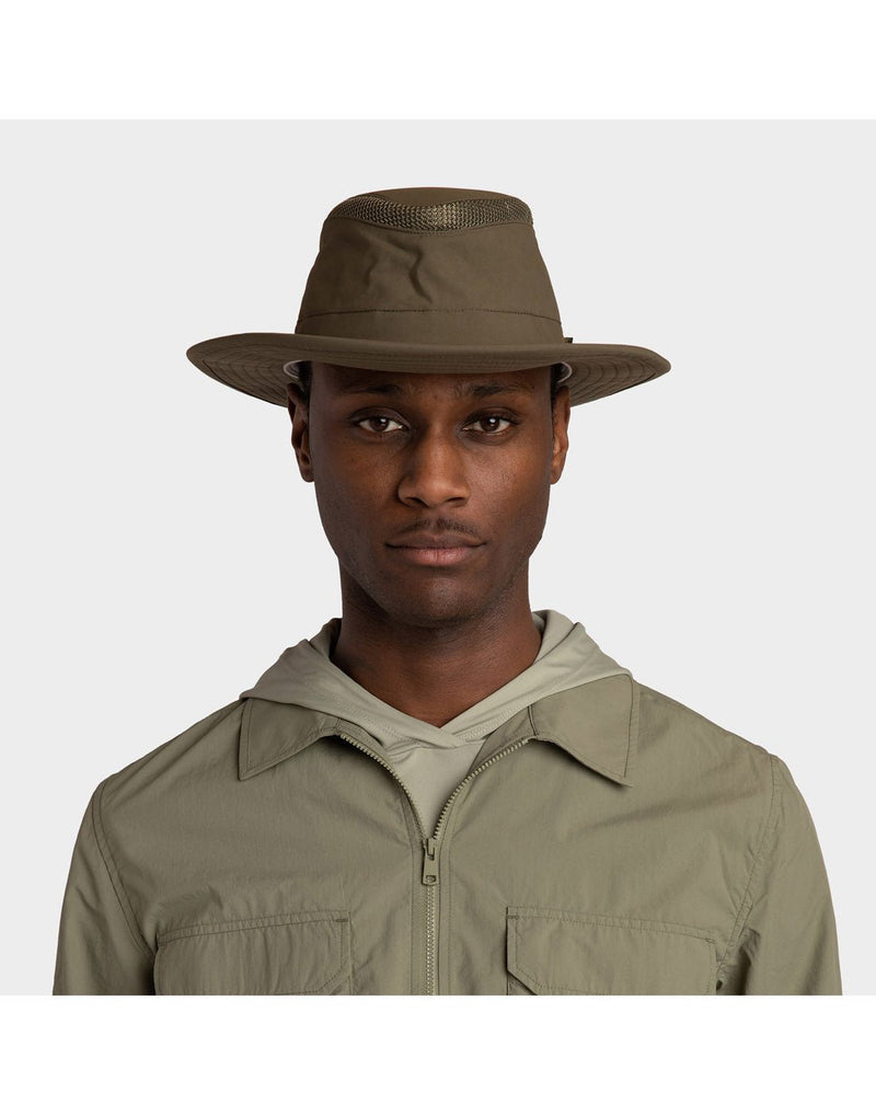 Portrait image of a man wearing khaki zip up shirt and the olive Tilley LTM6 Airflo Hat, looking straight at camera