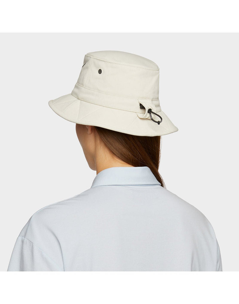 Portrait image of woman wearing light blue button shirt and Tilley Tofino Bucket Hat in stone, back angled view