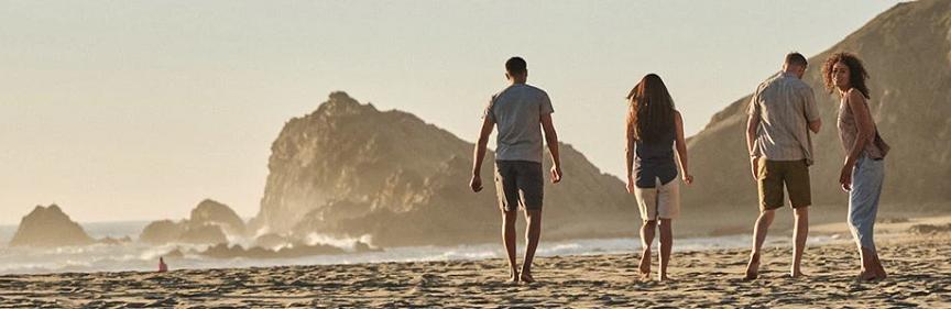 Four people walking on beach in leisure