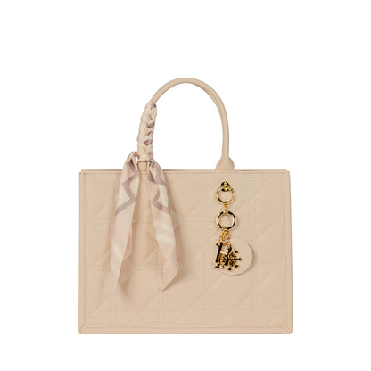 The Sayan Top Zip Handbag Tote features a cream quilted design, scarf handle, and gold charms for chic style.