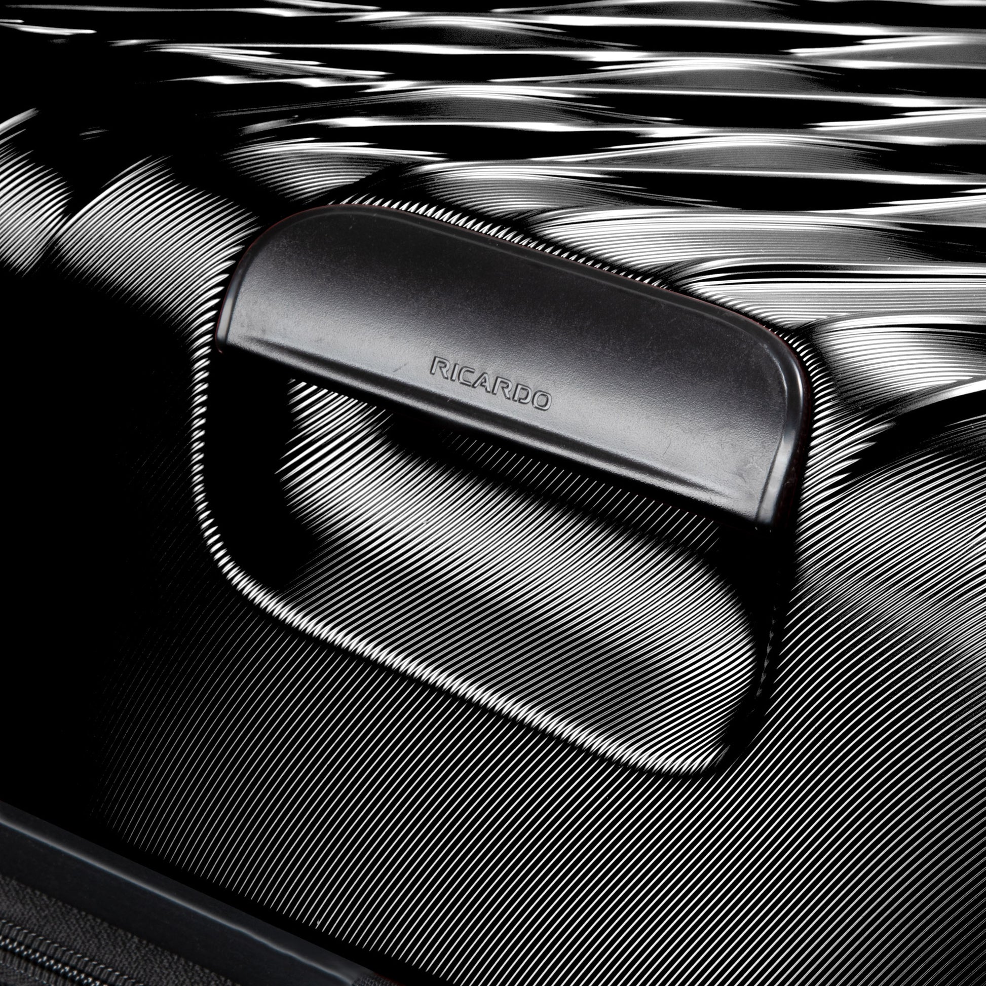 Close-up of Ricardo Beverly Hills Melrose 20" Hardside Spinner Carry-on handle and textured black surface.