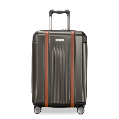 Ricardo Beverly Hills Montecito 2.0 graphite gray carry-on with brown accents, spinner wheels, and TSA lock.