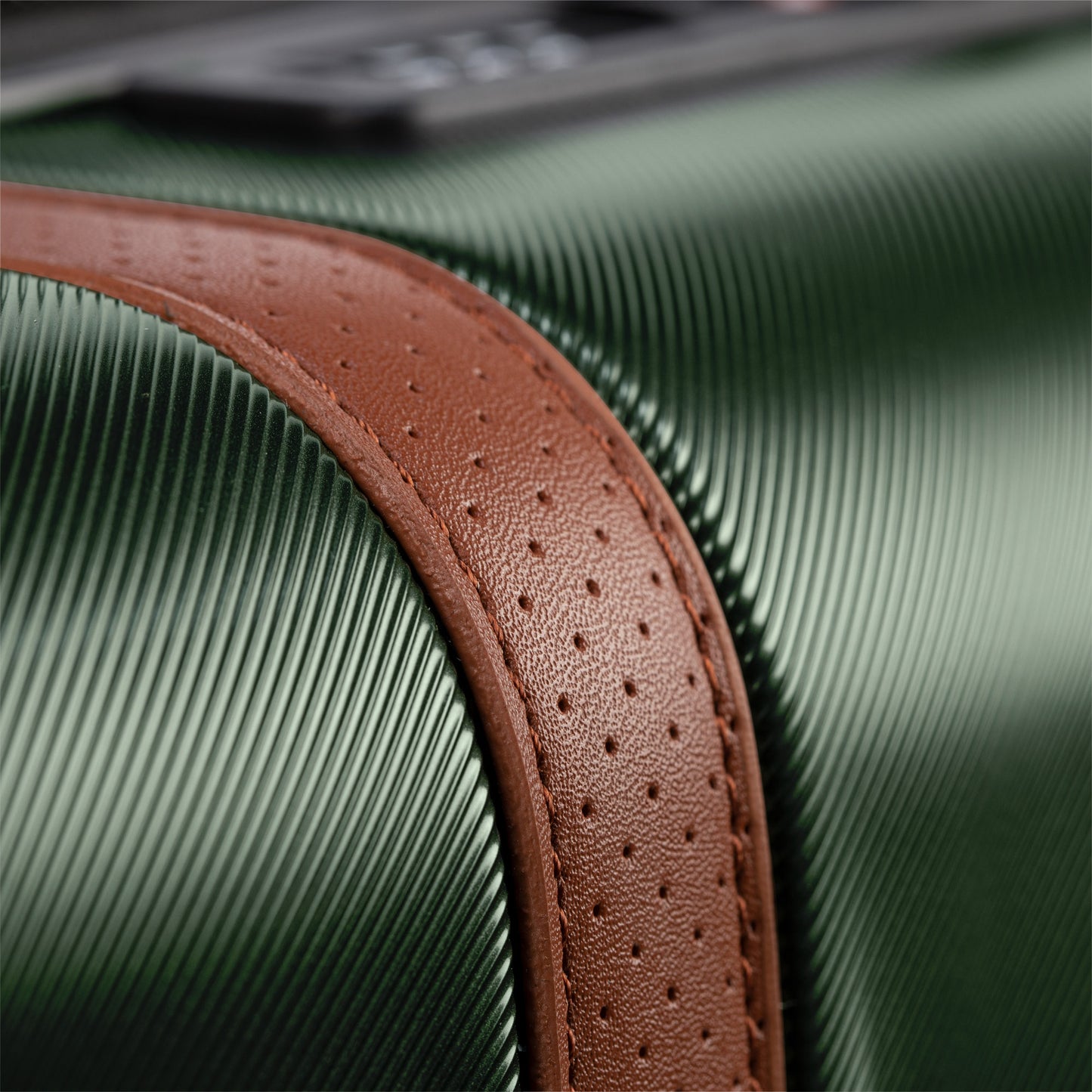 Close-up of Ricardo Beverly Hills' Montecito 2.0 green hardside carry-on with a brown leather strap detail.