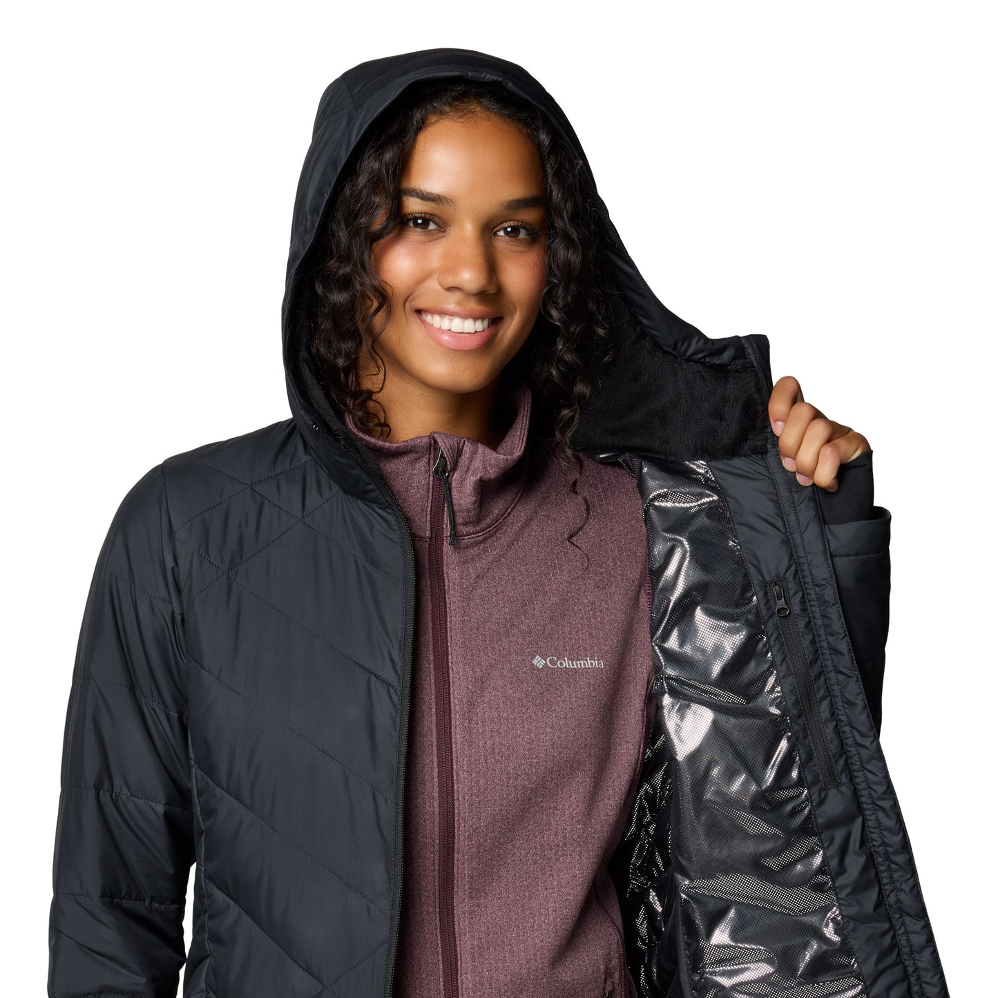 Top half of woman wearing Columbia Women's Heavenly™ Long Hooded Jacket in black, with the hood up and holding one side open to show silver lining