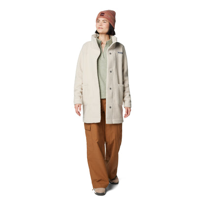 Woman wearing Columbia Women's Panorama™ Long Jacket in dark stone colour, unbuttoned on top of light green sweater and orange pants