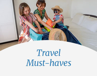 Mother and two daughters packing luggage in a room. Travel Must-haves.
