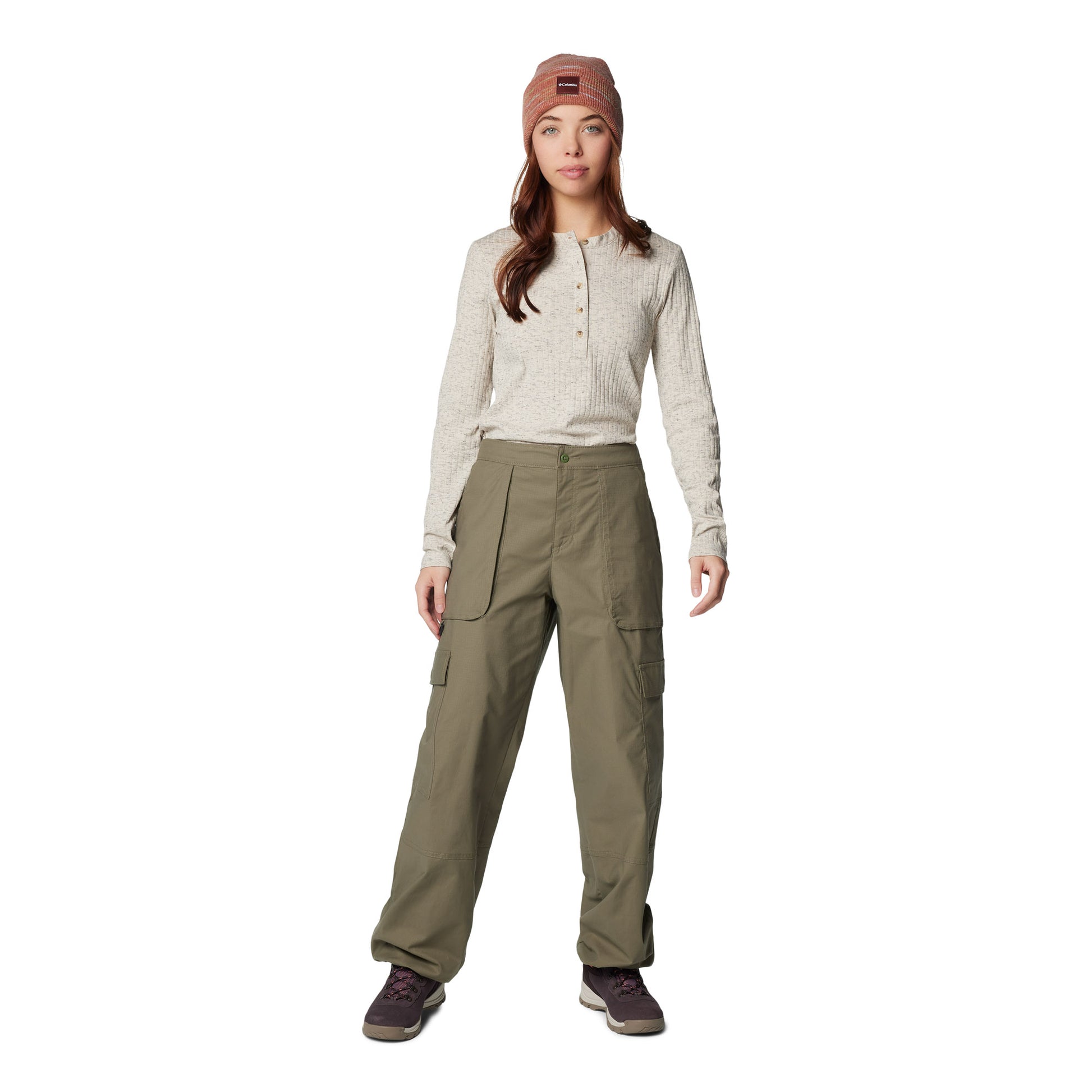 Woman wearing Columbia Women's Brea Falls™ Henley Long Sleeve Shirt in dark stone tucked into green pants and wearing an orange toque