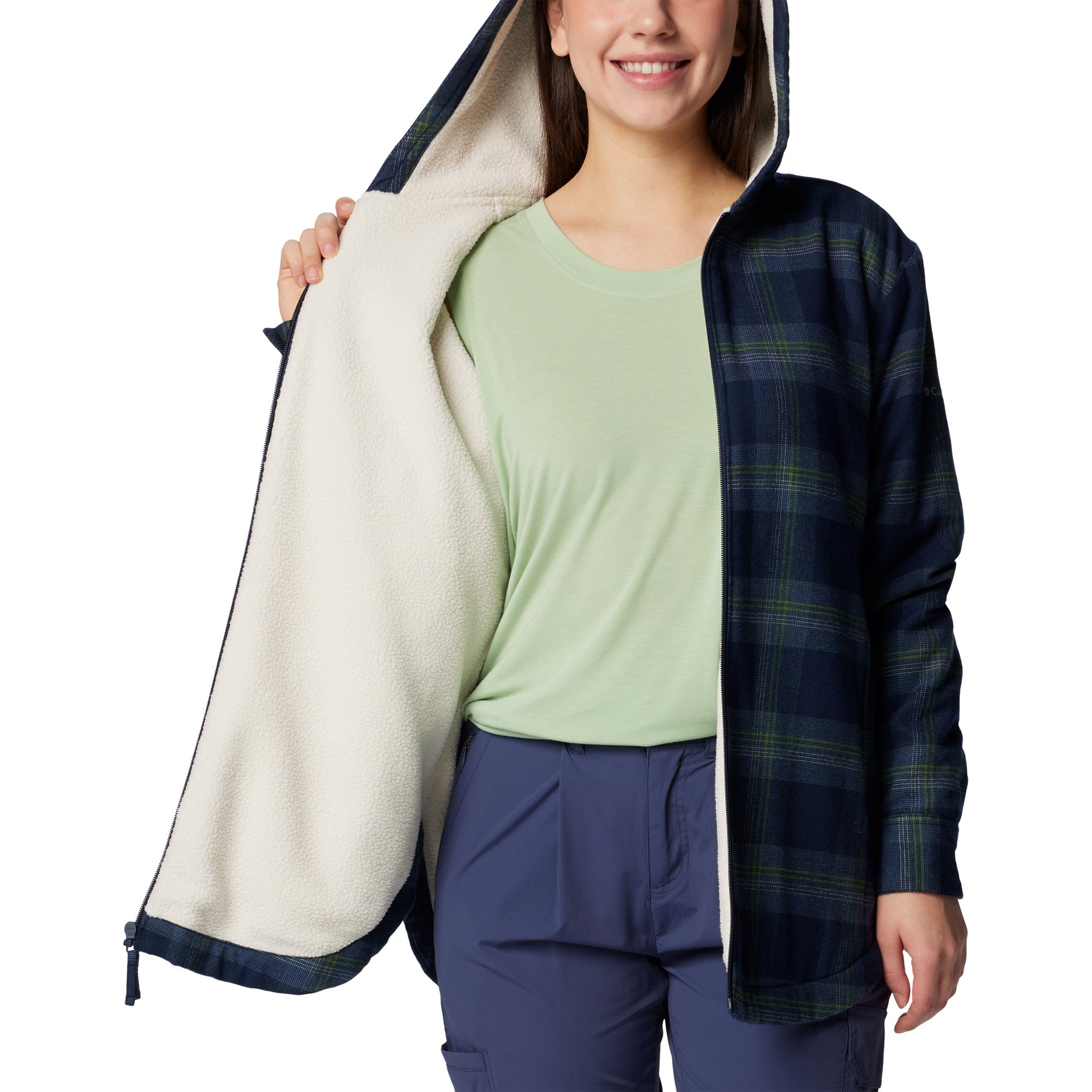 Woman wearing Columbia Women's Holly Hideaway™ Warm Lined Flannel Shirt Jacket in collegiate navy, front view, unzipped, holding one side open to show sherpa lining inside