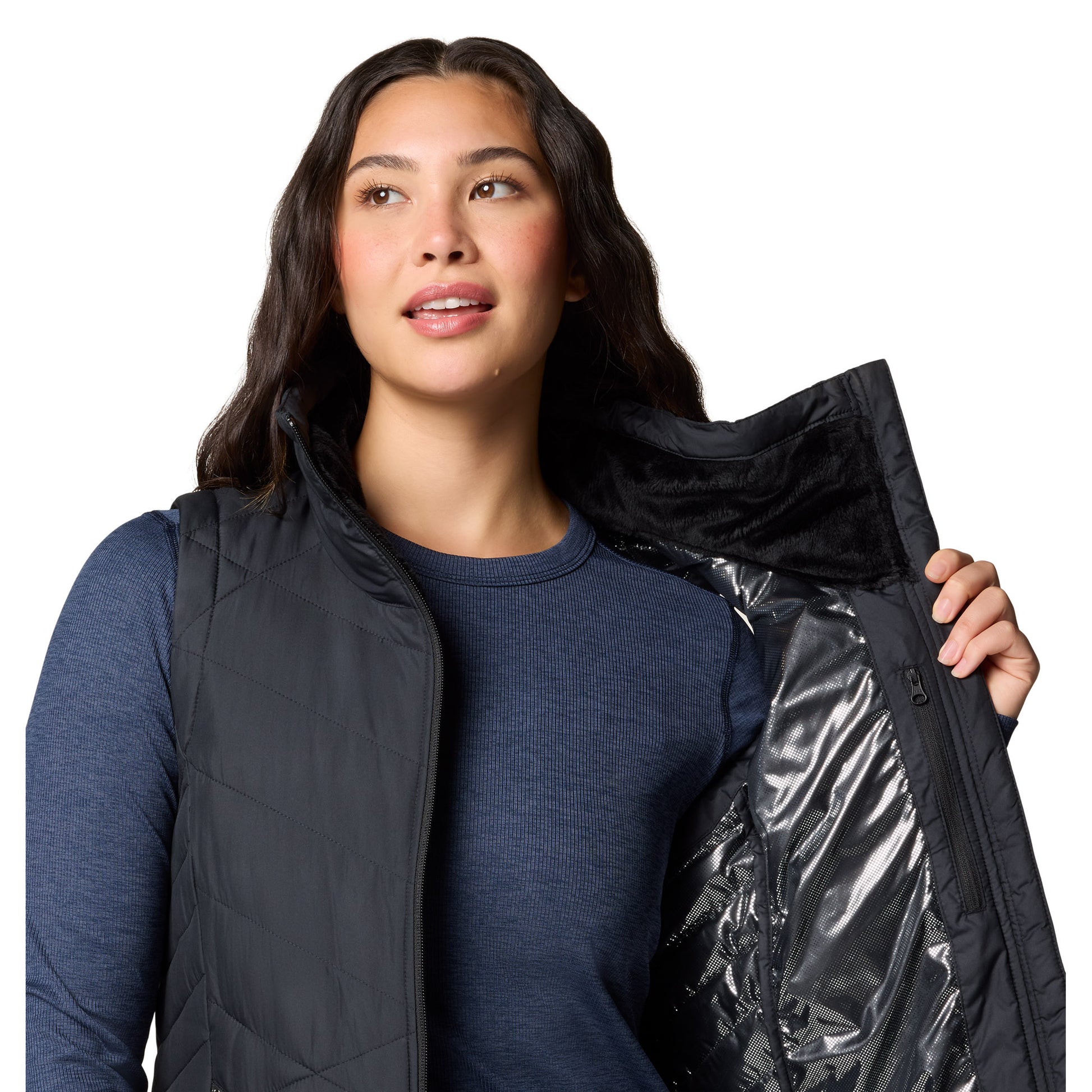 Top half of woman wearing Columbia Women's Heavenly™ II Long Vest in black, unzipped, holding one side open to show omni-heat silver lining