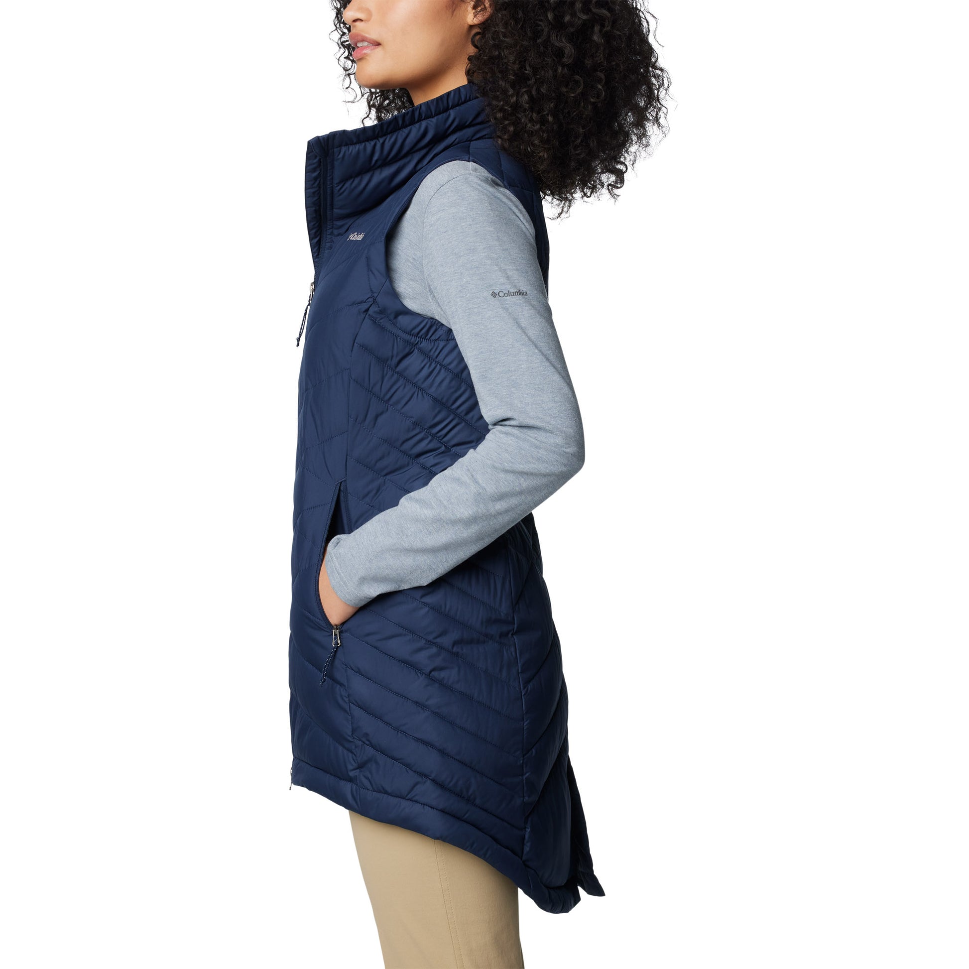 Woman wearing Columbia Women's Heavenly™ II Long Vest in collegiate navy, side view, with hands in pockets