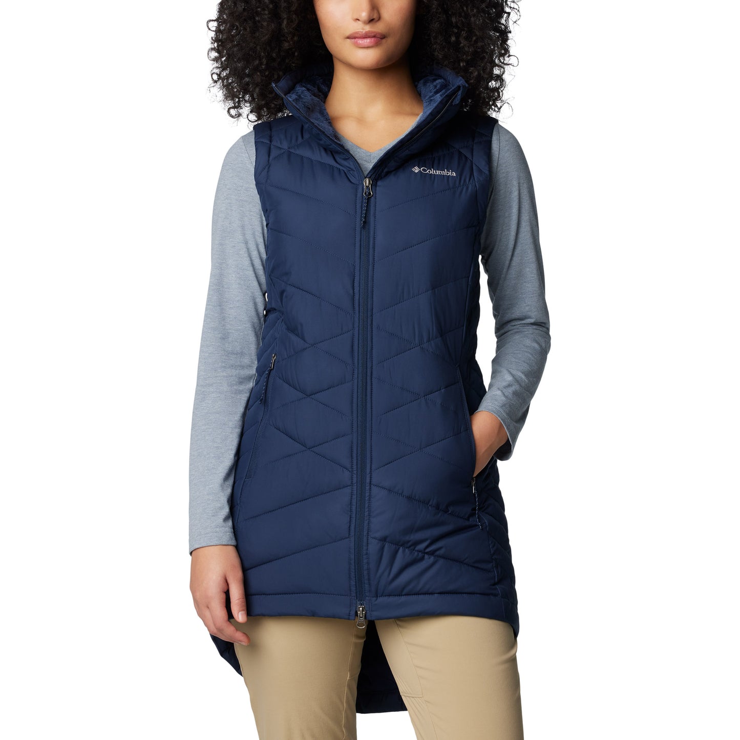 Woman wearing Columbia Women's Heavenly™ II Long Vest in collegiate navy, front view, zipped up with one hand in pocket